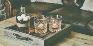 Whiskey gift set with glasses on a wooden tray.