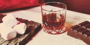 Chocolate whiskey cocktail ingredients: whiskey, chocolate, and marshmallows.