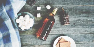 Unusual whisky gifts for him: marshmallows, chocolate, crackers, and cozy blanket.