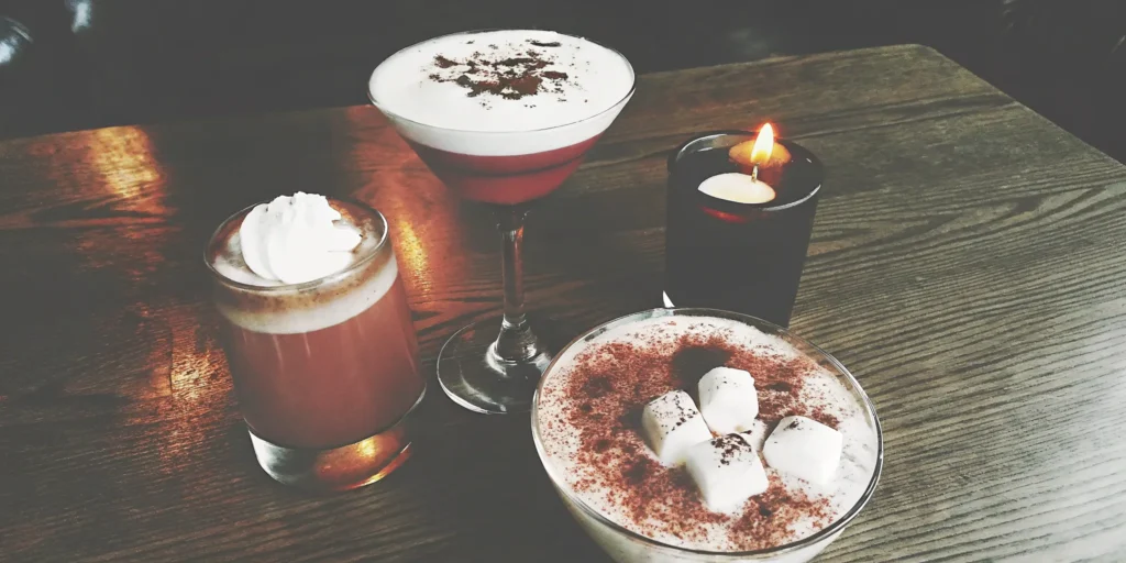 Rich whiskey dessert cocktails topped with chocolate, marshmallows, and cream.