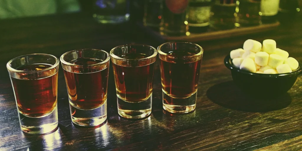 Four shots of good whiskey lined up on a bar, chosen for a smooth experience.