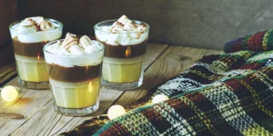 Creamy whiskey dessert drinks topped with whipped cream and toasted marshmallows.
