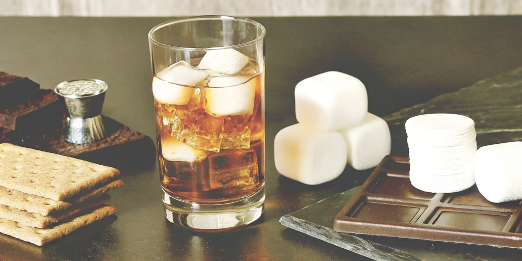 An easy s'mores whiskey cocktail with a toasted marshmallow and graham cracker garnish.