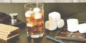 An easy s'mores whiskey cocktail with a toasted marshmallow and graham cracker garnish.