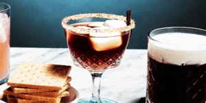 A s'mores whiskey drink idea with a graham cracker rim and toasted marshmallow garnish.
