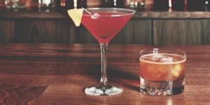 Two simple sweet whiskey cocktails, one in a martini glass and one in a rocks glass.