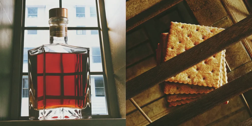 A bottle of amber liquor that tastes like graham crackers beside a stack of the crackers.