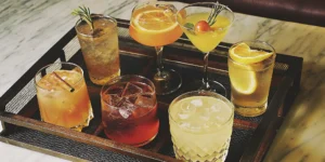 A variety of honey whiskey drink recipes served as cocktails with citrus and herb garnishes.
