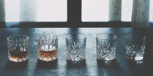 A crystal bourbon and glass set with two glasses filled and ready for a tasting.