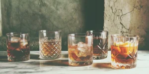 Several cinnamon whiskey drink recipes served in glasses with ice.