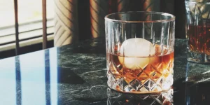 A perfectly clear ice sphere chilling a glass of whiskey.