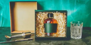 Whiskey gift basket ideas featuring a bottle of whiskey, a glass, and essential bar tools.