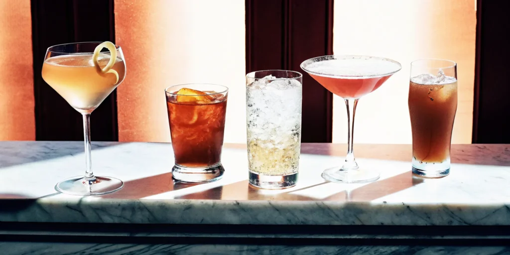 Five unique maple bourbon drink recipes served in various cocktail glasses.