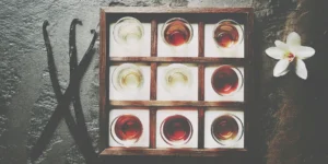 A glass of whiskey with whole vanilla beans, a source of natural vanilla notes.
